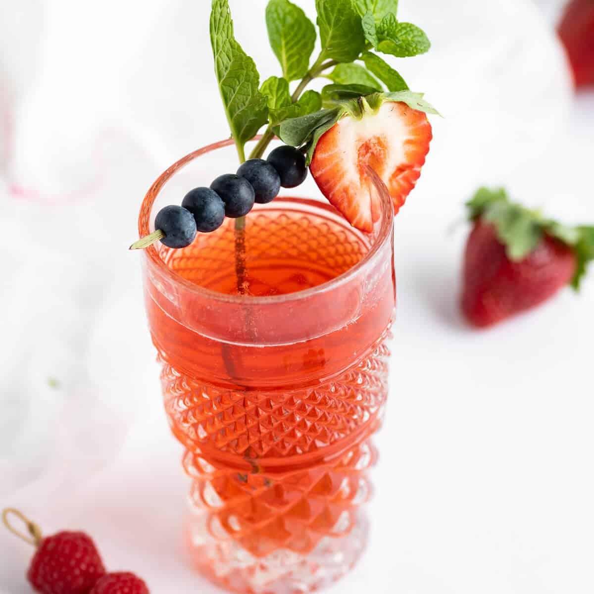 a variety of kombucha flavors with visible fizz and fruit pieces at the bottom of the glass