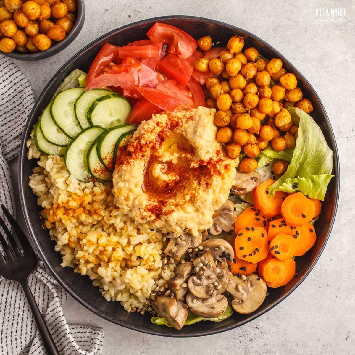 Overhead shot of a vibrant Bobotie Hummus Bowl with various toppings