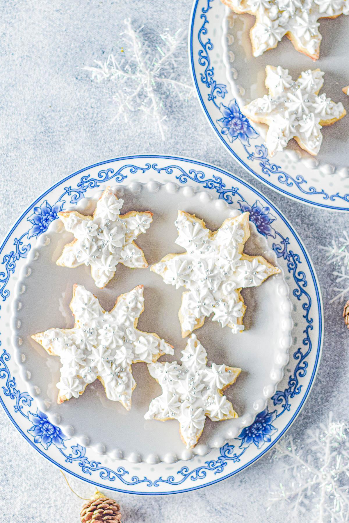 A beautifully arranged platter of shiny, perfectly decorated snowflake sugar cookies, festive setting