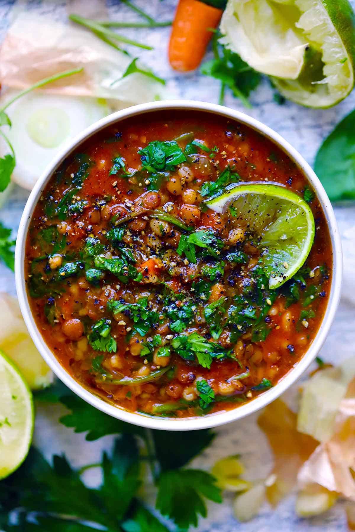 bowl of barley lentil soup with parsley garnish