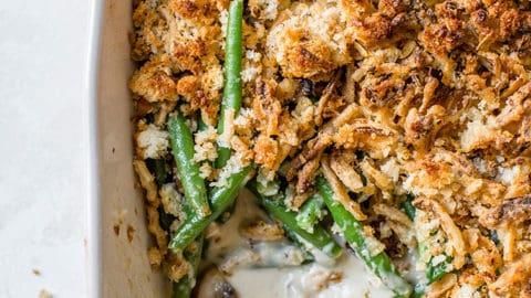 Creamy green bean casserole baking in an oven, bubbling gently with a golden-brown surface.