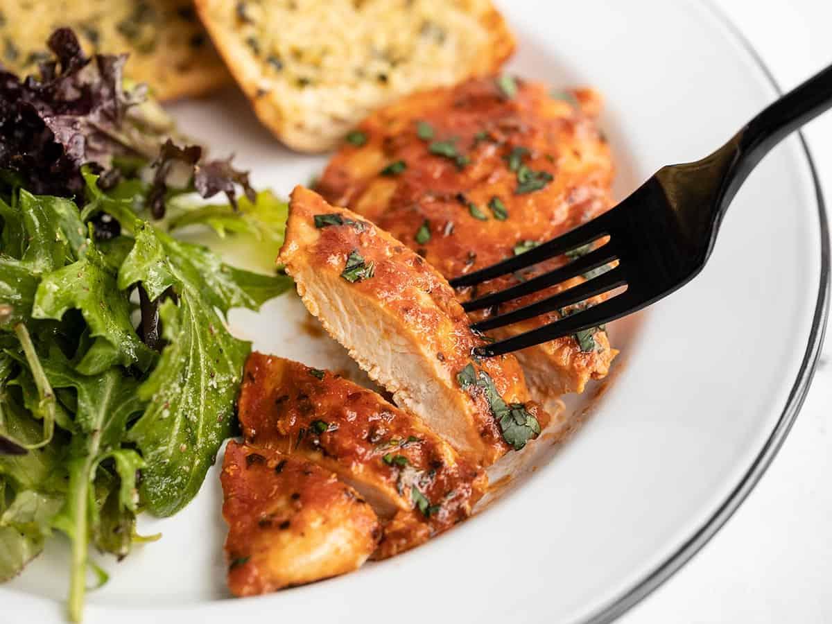 slice of tomato basil chicken casserole on a plate with a fork