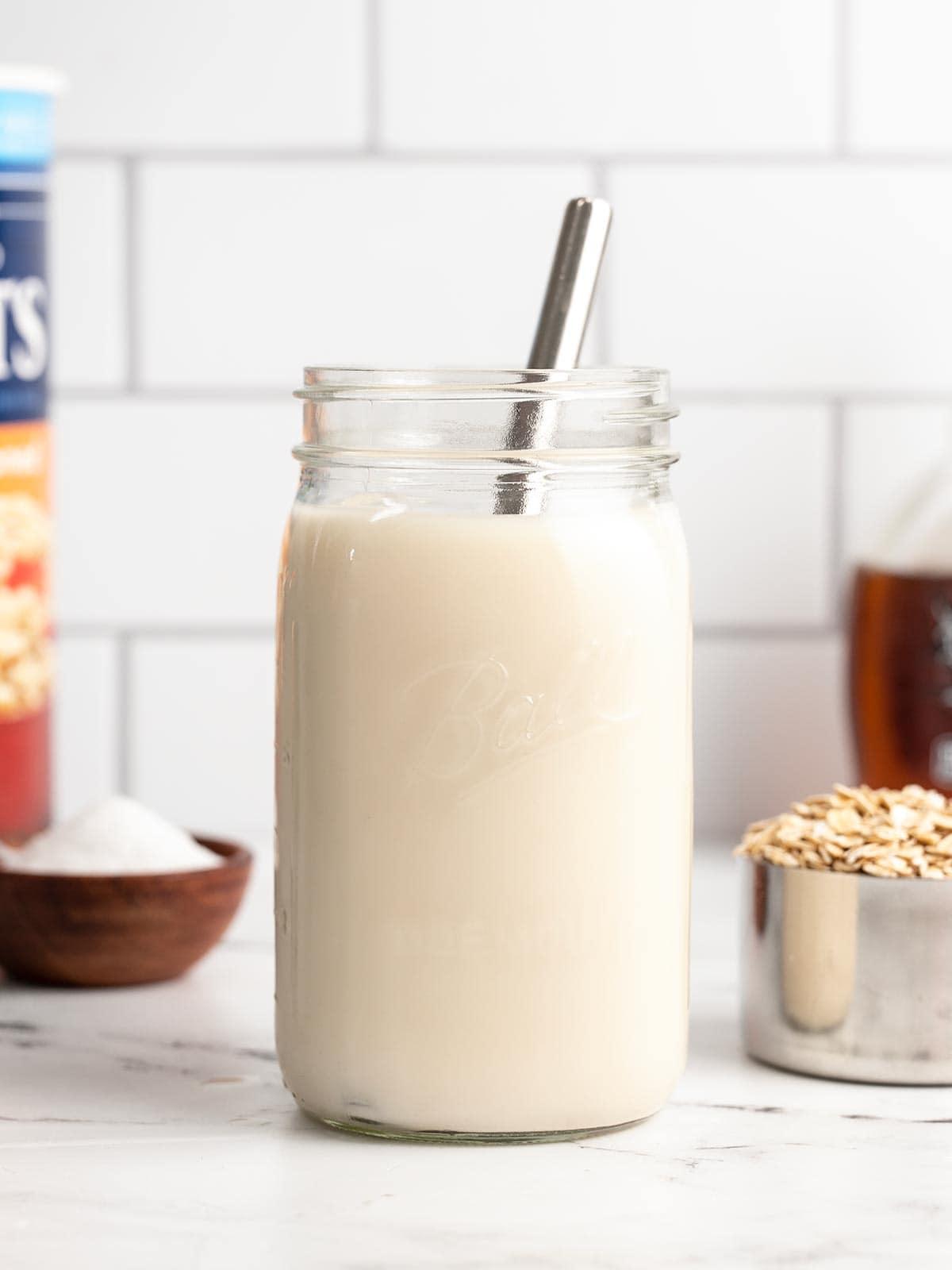 a glass of homemade oat milk with a straw