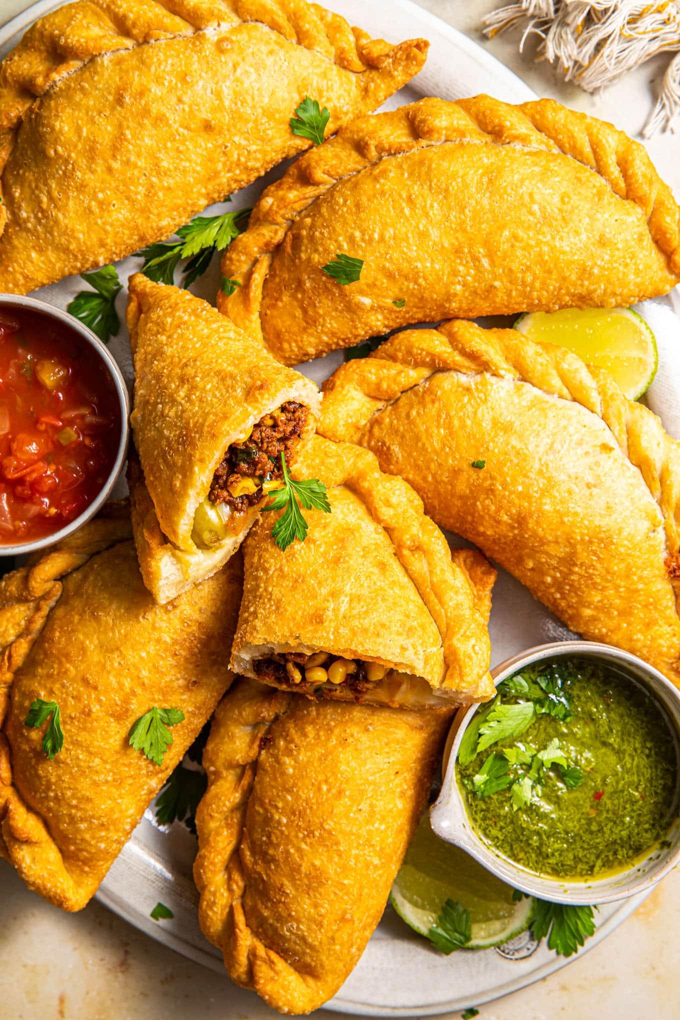 A variety of colorful empanadas with different fillings displayed on a platter
