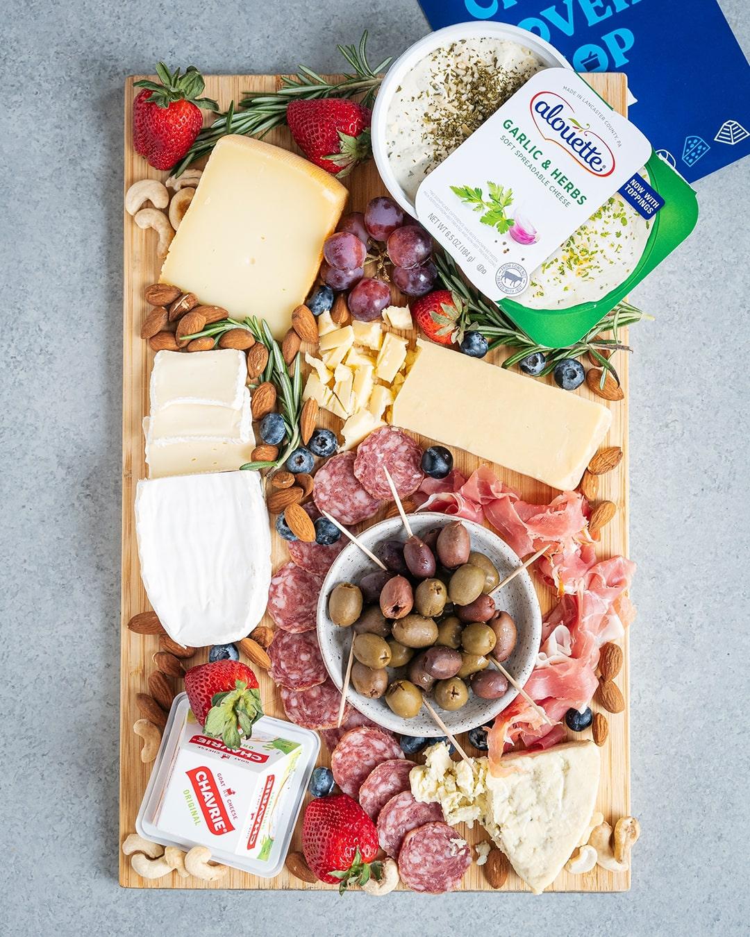 overhead shot of garlic herb keto cheese wafers arranged on a wooden serving board with keto friendly dips