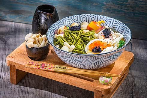 bowl of matcha ramen with various toppings