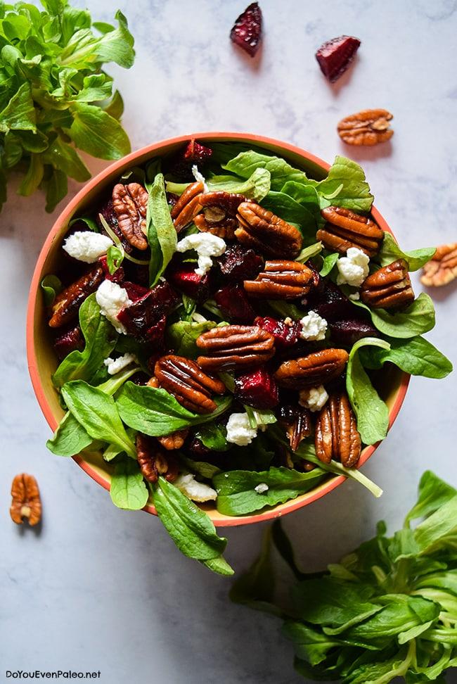 overhead shot of a person preparing mâche salad with beets and goat cheese in a kitchen