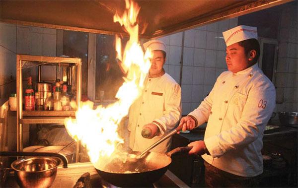 chef expertly tossing ingredients in a wok over an open flame