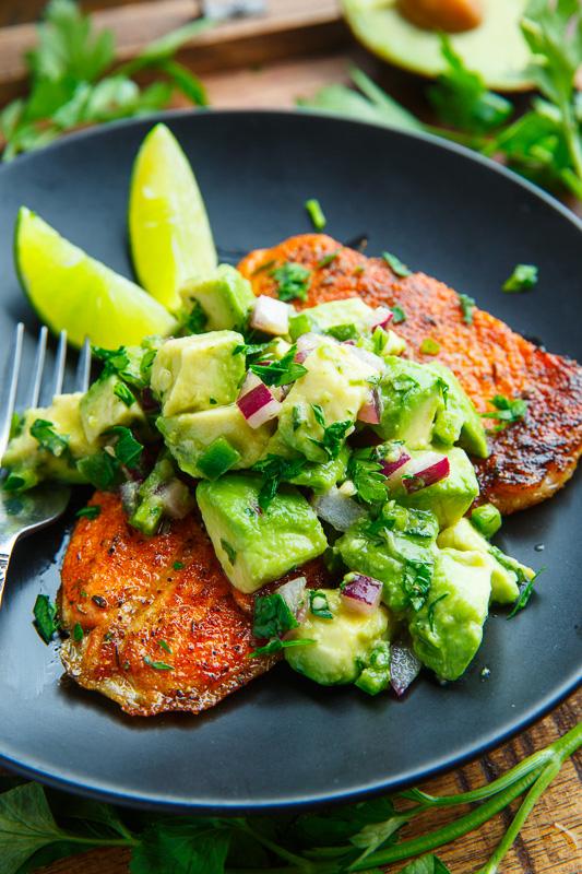 close-up shot of someone taking a bite of spicy keto avocado and blackened salmon salad