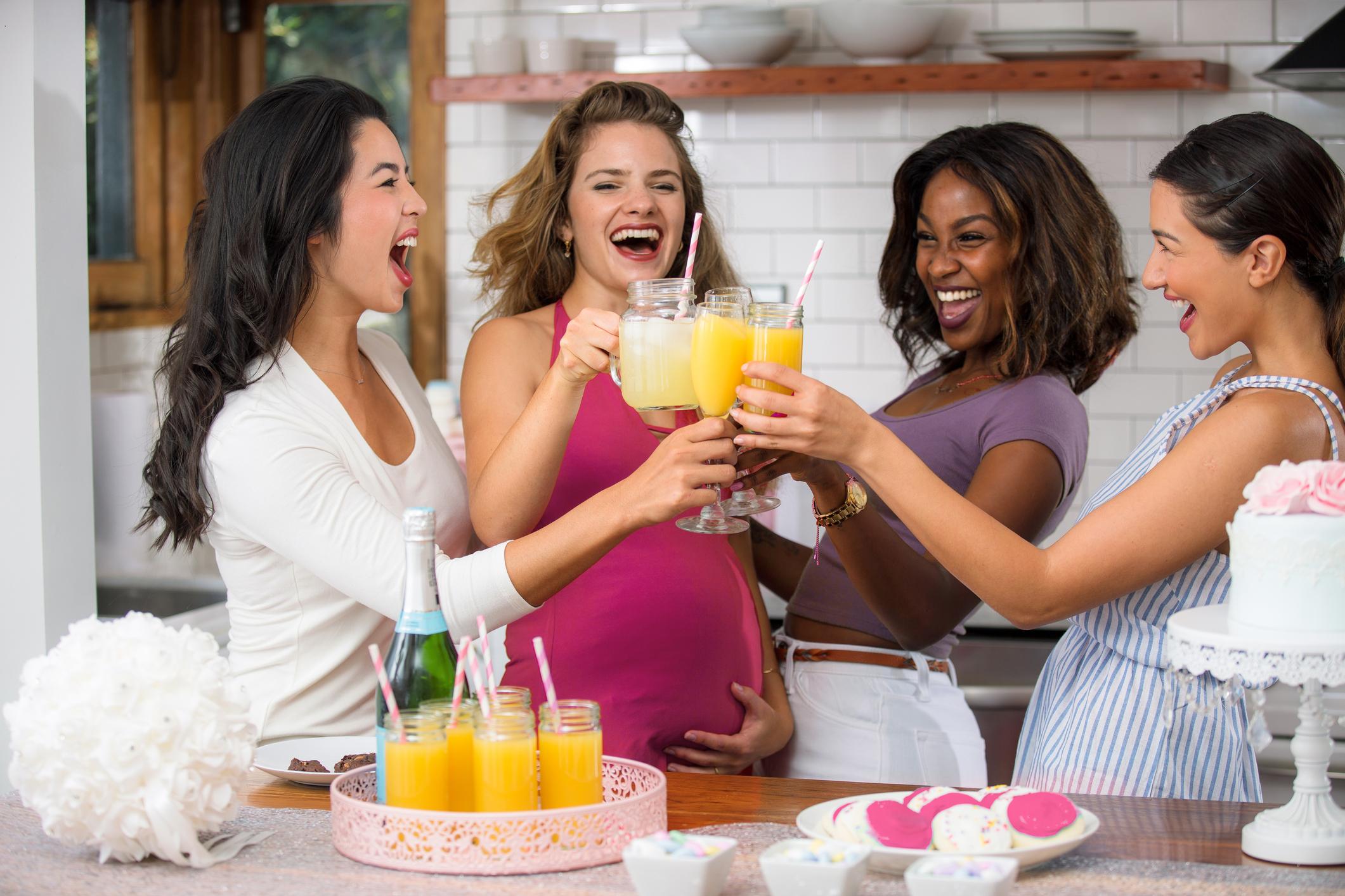 people making mimosas at a brunch party, laughing and having fun