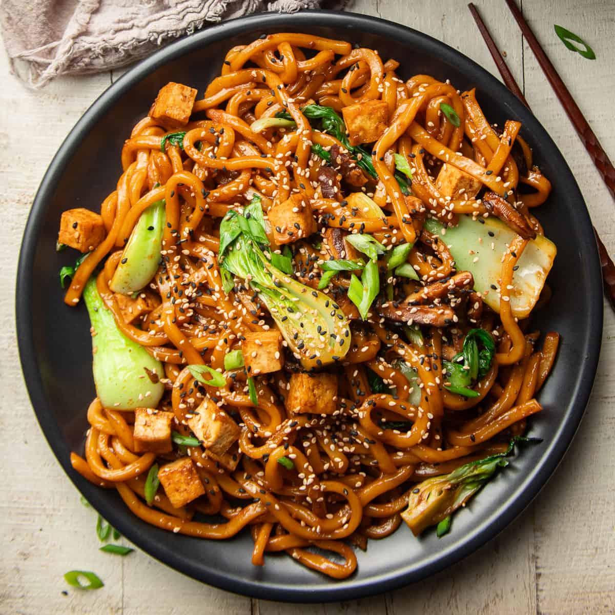 a family enjoying banana udon noodle stir-fry at the dinner table
