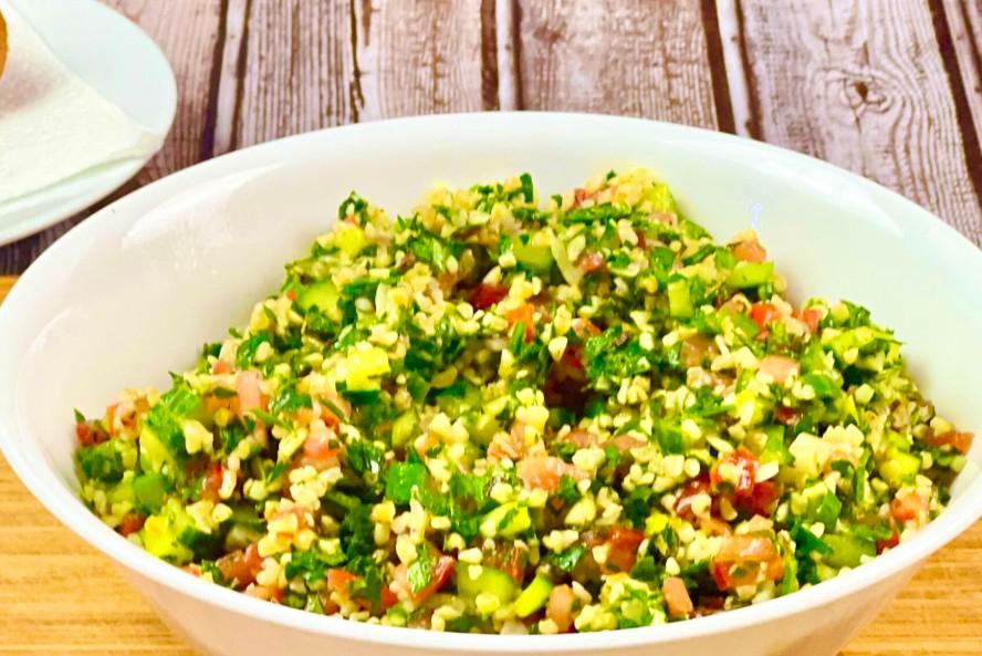 A vibrant bowl of rustic tabbouleh with whole grains and fresh herbs