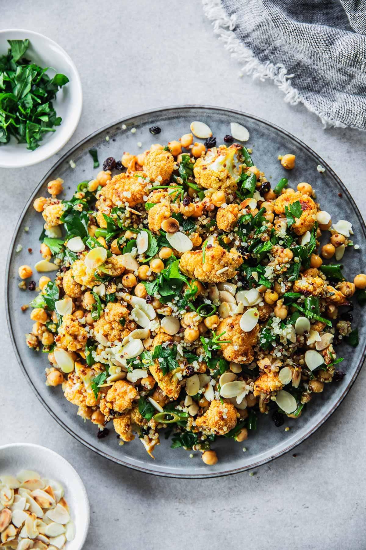 A beautifully styled bowl of roasted cauliflower rice salad with toasted nuts and seeds