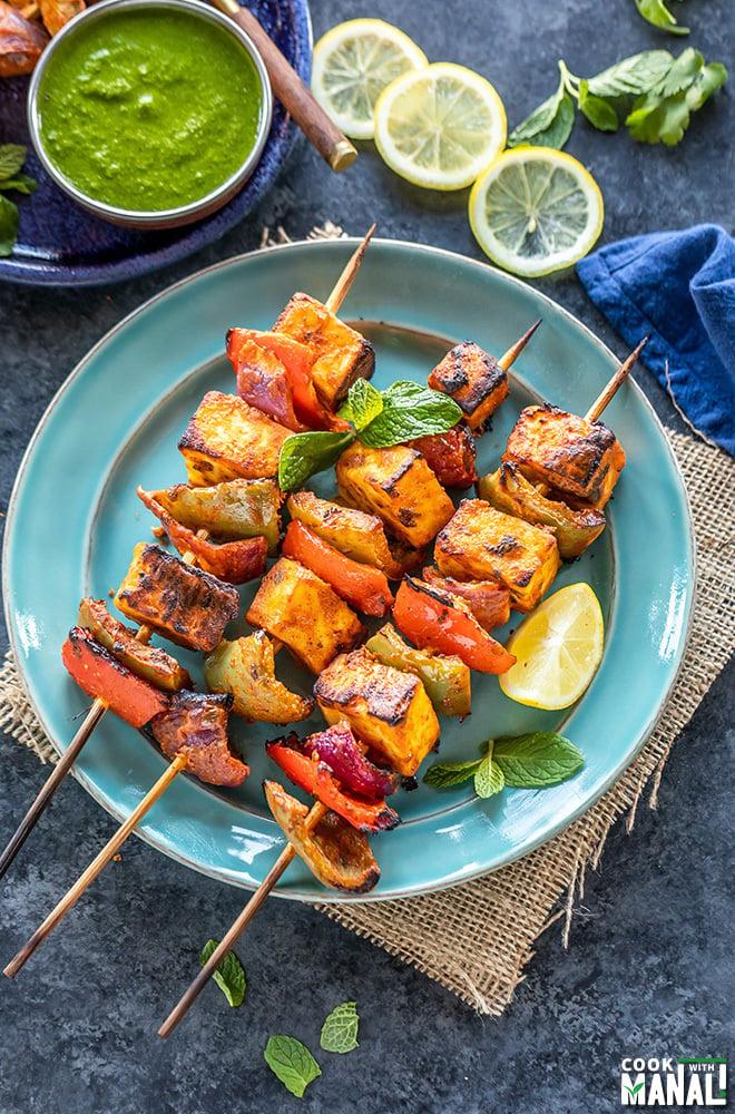 Paneer tikka being grilled on skewers