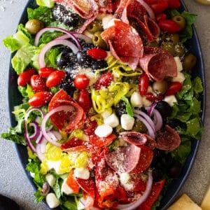 overhead shot of a prepared strawberry antipasto salad with various ingredients around it