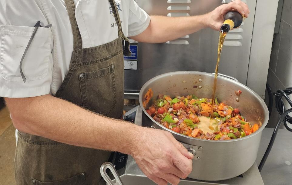 chef stirring texas chili in a pot