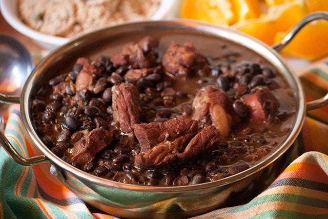 Authentic feijoada dish with liverwurst and pickles served in a rustic setting