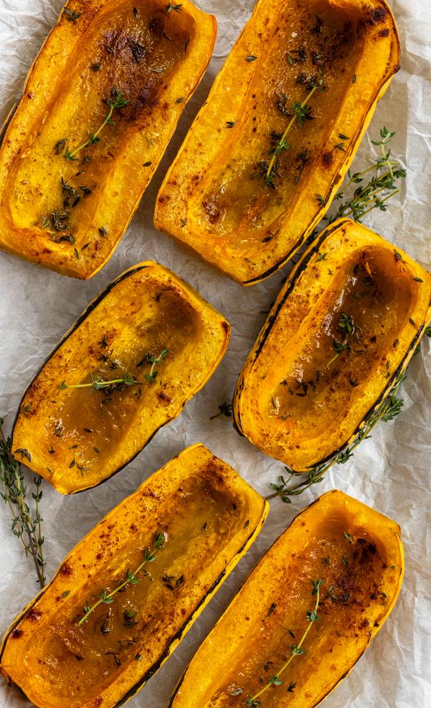 delicata squash halves roasting in the oven