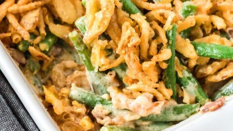 A warm, inviting kitchen scene with a partially assembled green bean casserole in a baking dish
