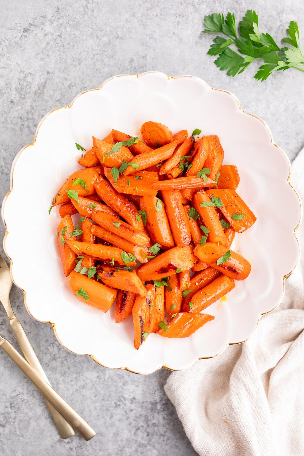 Vibrant honey-glazed carrots with fresh herbs on a festive Thanksgiving table setting