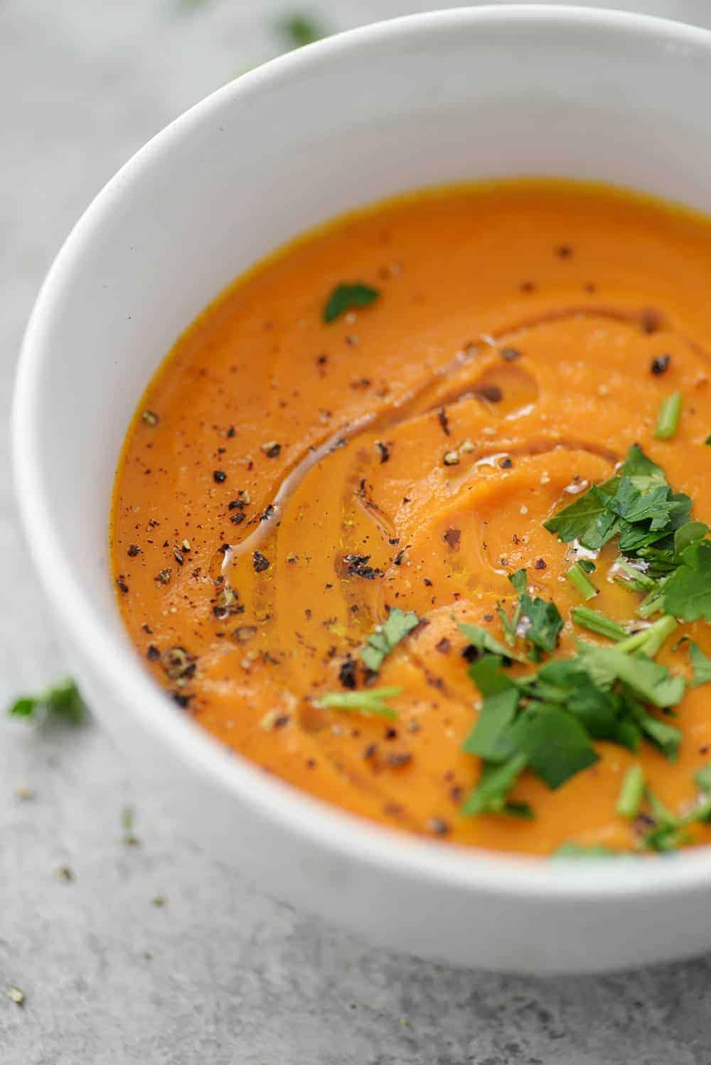 Close-up shot of a steaming bowl of carrot ginger soup
