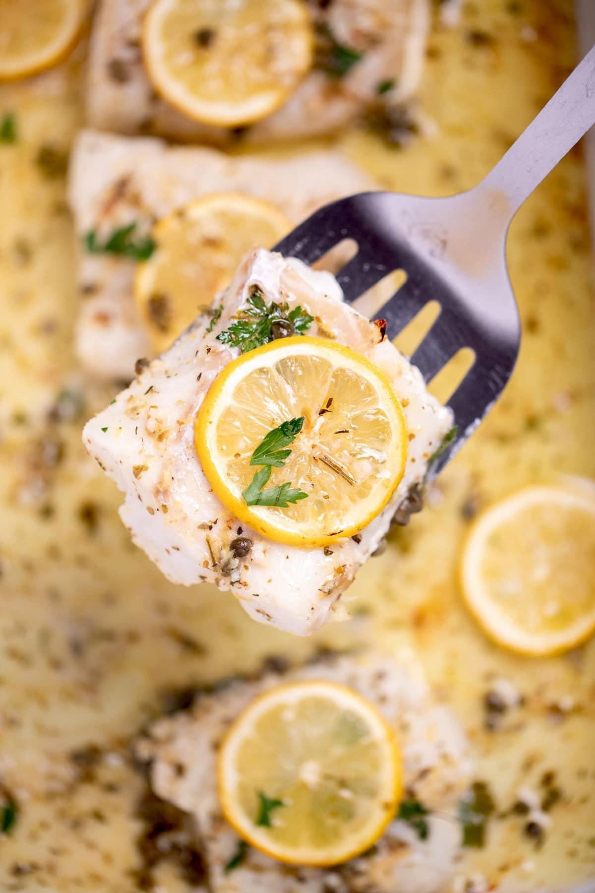 fresh cod fillets on a cutting board with lemon and butter