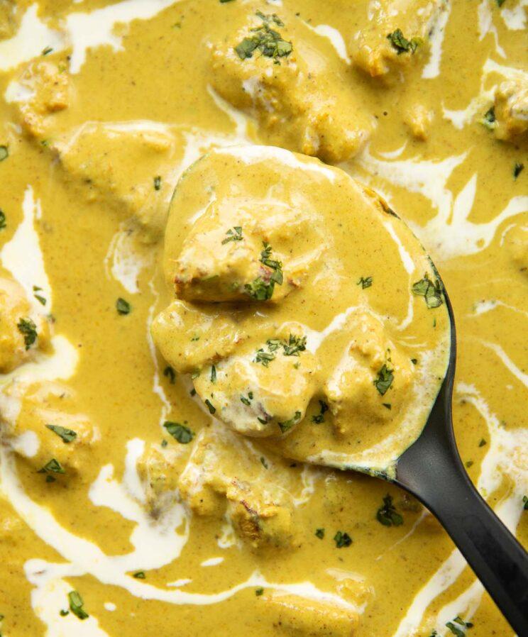 Close-up shot of the Chicken Korma topping on the pizza, highlighting the creamy sauce and tender chicken