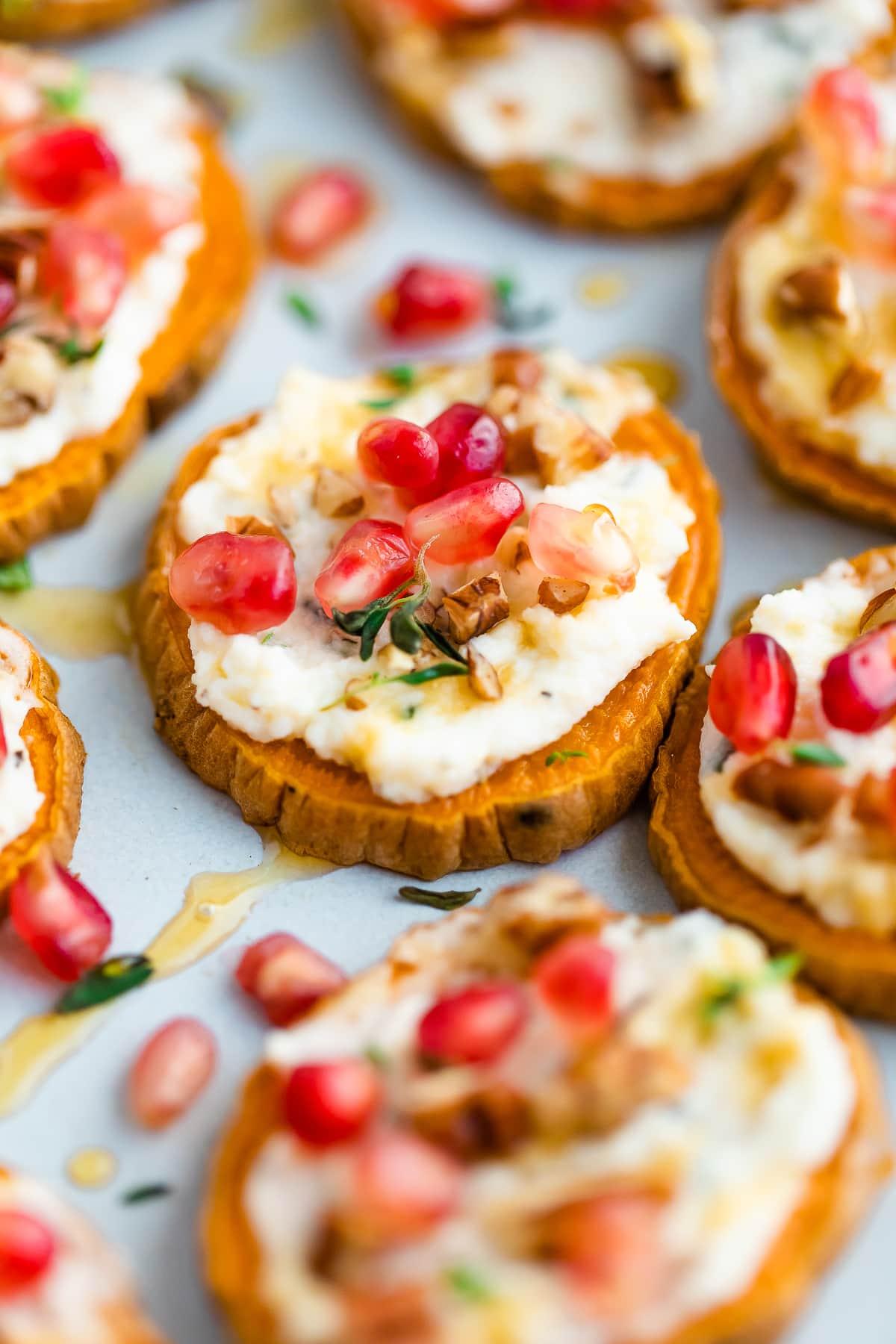 Close-up of glazed sweet potato bites on a serving platter with a sprinkle of fresh herbs