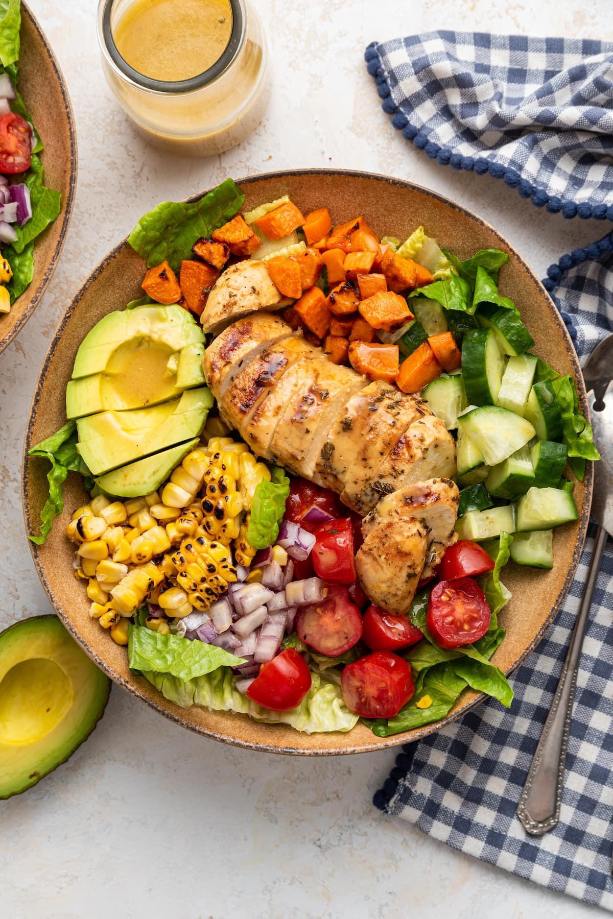 A colorful and delicious salad with grilled chicken or chickpeas, mixed greens, berries, and feta cheese.