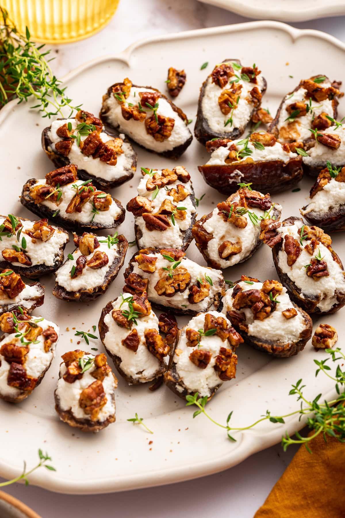 Several callaloo and goat cheese stuffed dates arranged on a platter