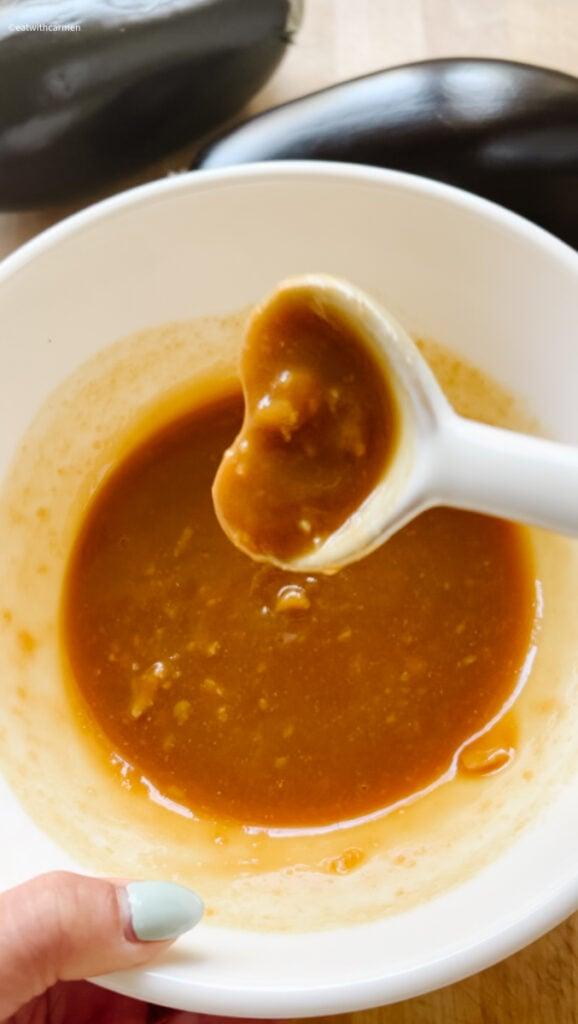 close up of a spoonful of miso glazed eggplant dip being lifted from a bowl