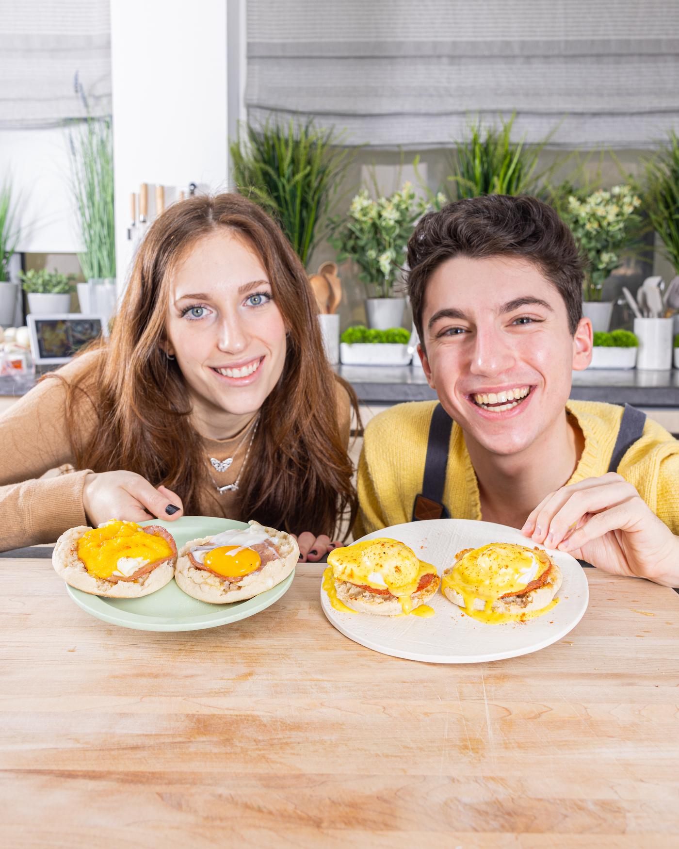 A person eating Eggs Benedict with a smile