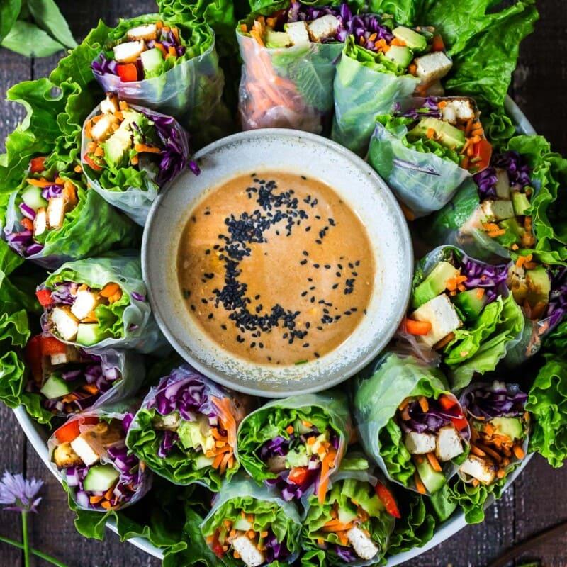 Delicious and colorful spring rolls on a plate with dipping sauces