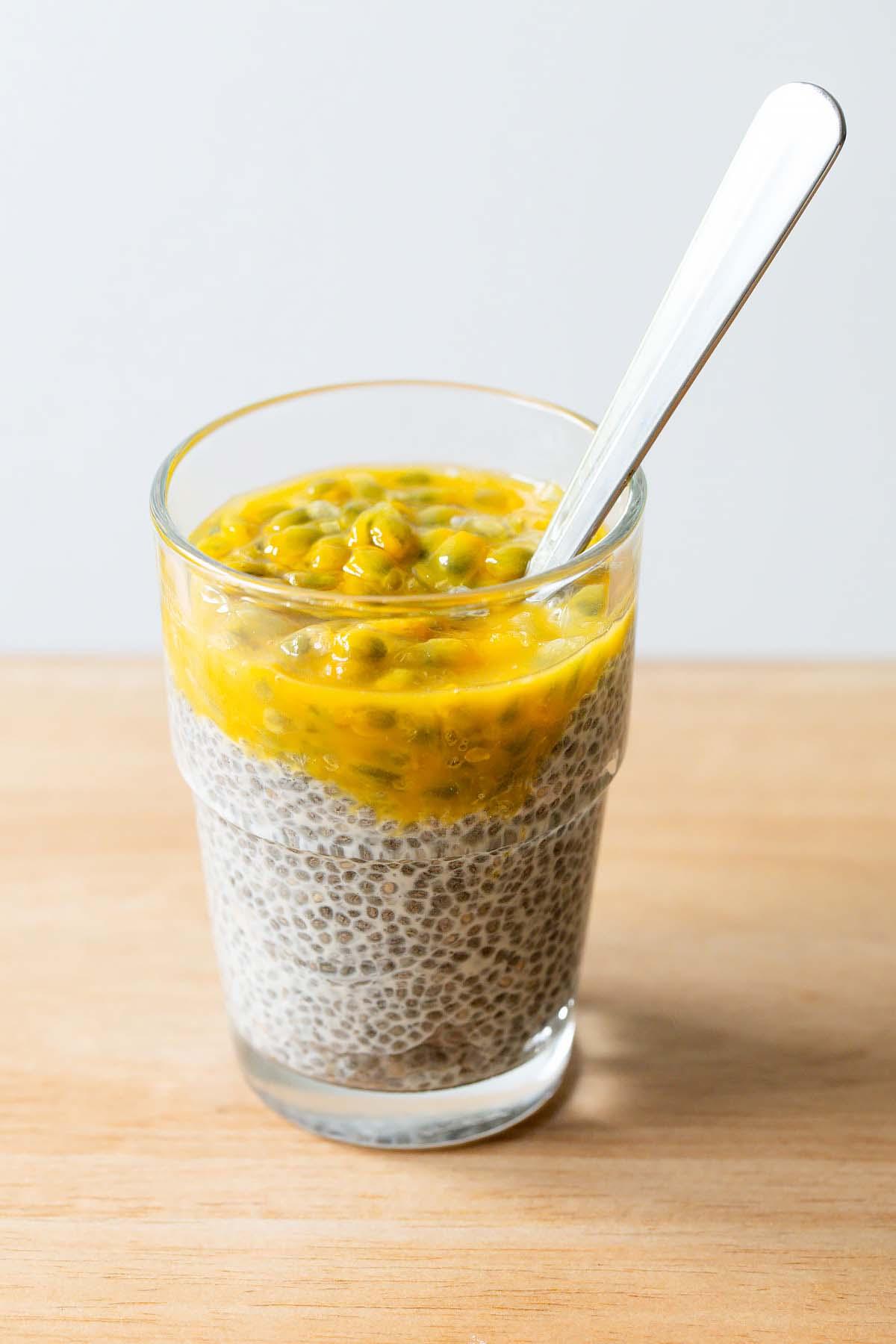 close up shot of a spoon scooping up guava passionfruit chia seed pudding