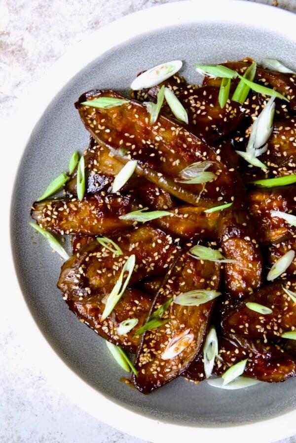 Close-up shot of two perfectly glazed eggs with sesame seeds, glistening in the light. The gochujang glaze is visible, rich in color.