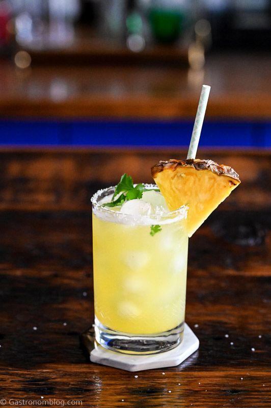 pineapple cilantro serrano mimosa garnished with pineapple wedge and cilantro sprig