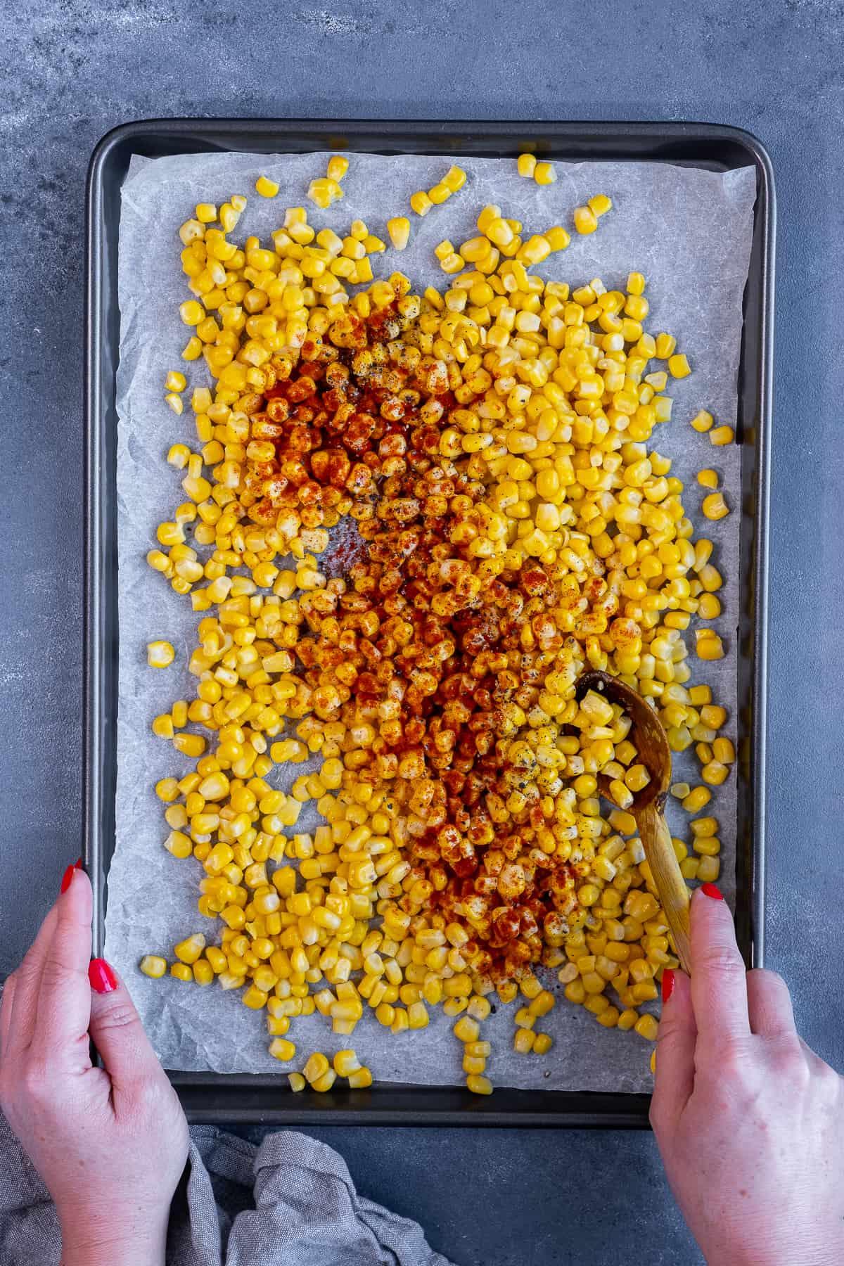 close up shot of raw corn kernels on a baking sheet, ready for roasting