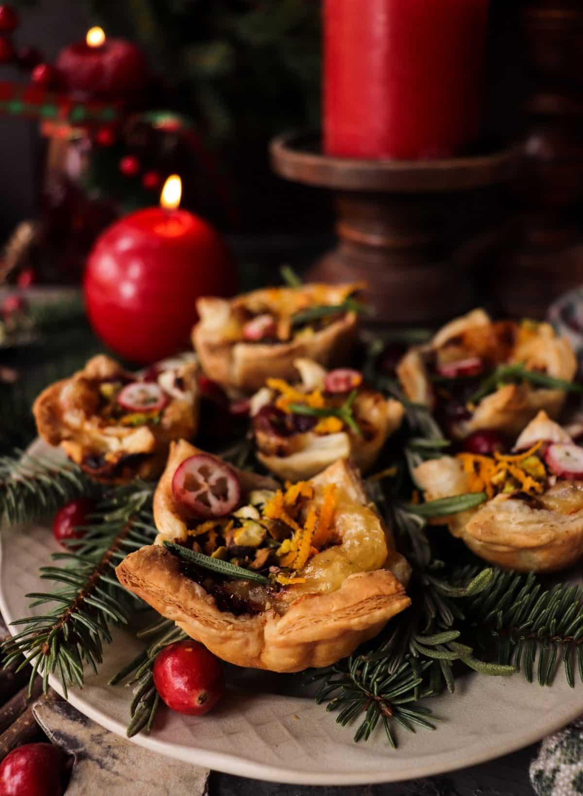Elegant holiday cranberry appetizer tarts on a festive platter, close-up, warm lighting