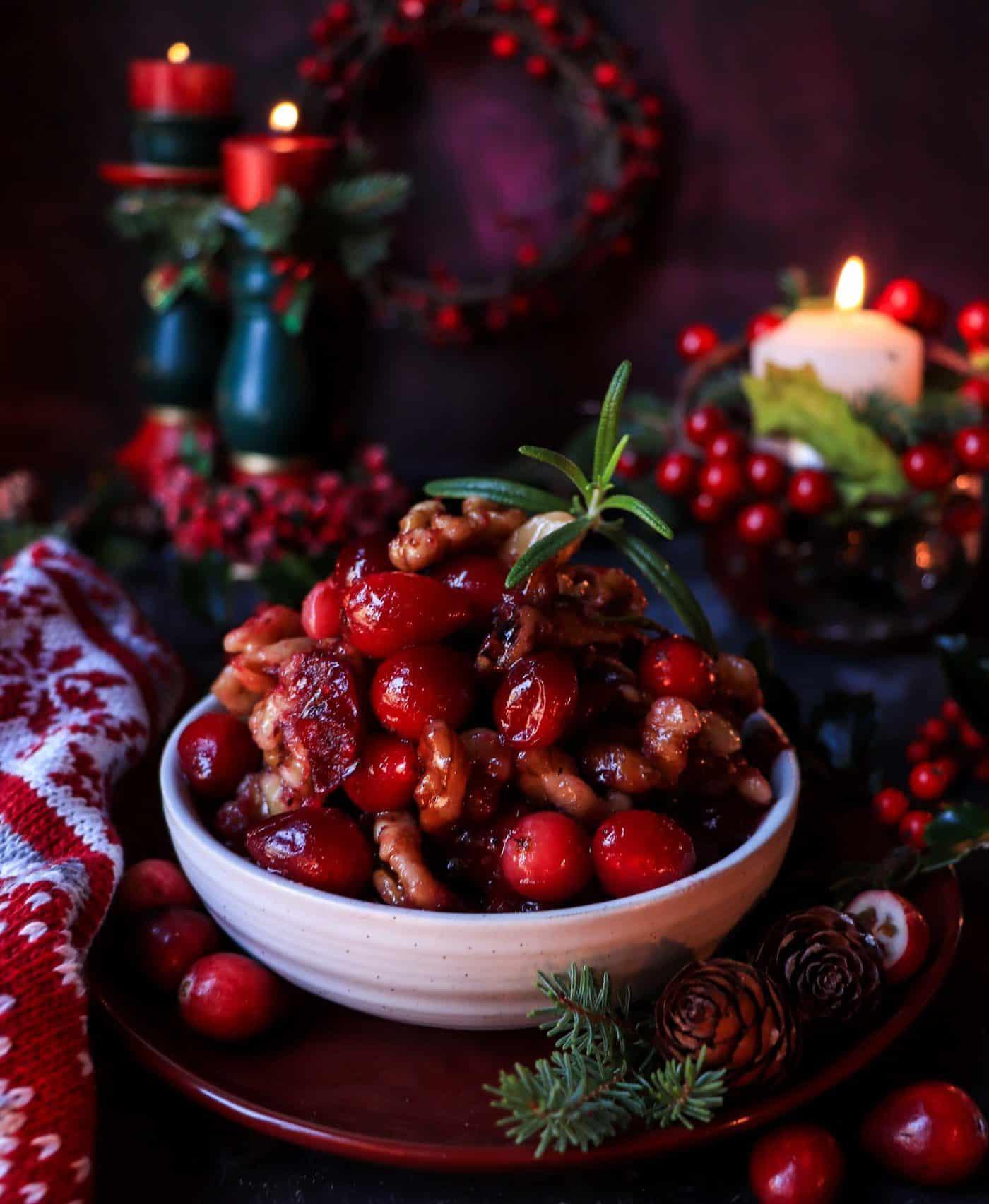 A beautifully set holiday table with a bowl of cranberry sauce as a centerpiece.