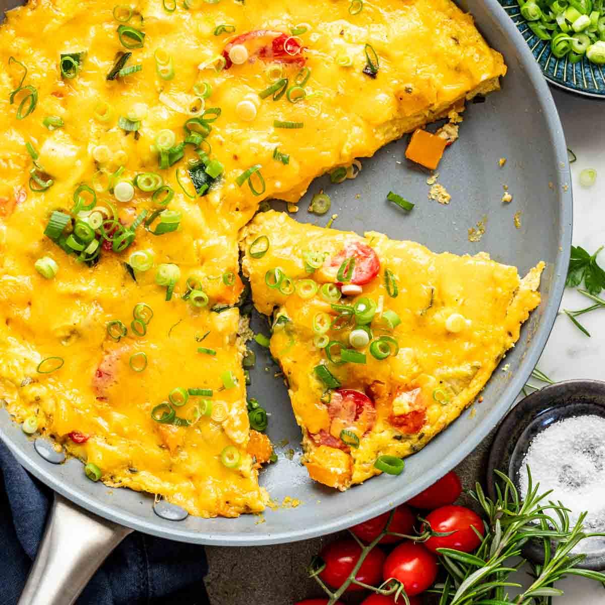 a close-up shot of the zero-waste frittata being sliced into wedges, showcasing the colorful array of vegetables inside
