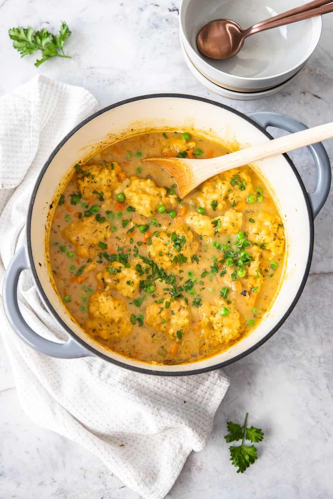 overhead shot of a pot of lentil soup with dumplings cooking