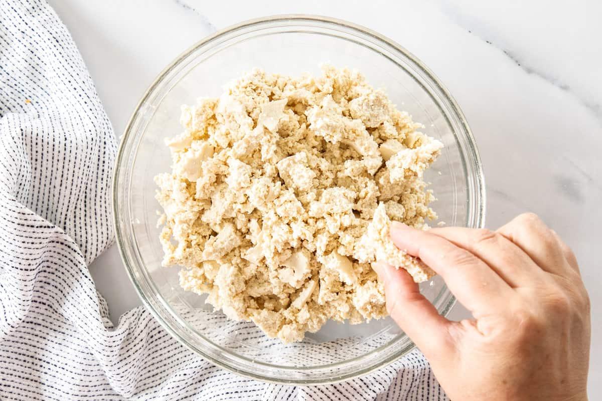 Tofu being crumbled in hands for a tofu scramble