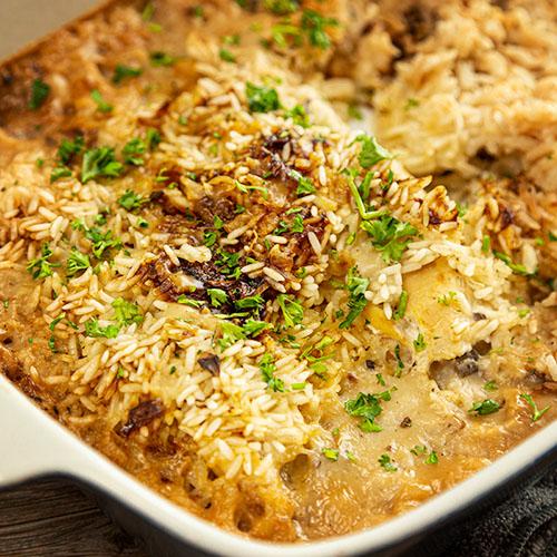 casserole dish with raw chicken and rice mixture before baking