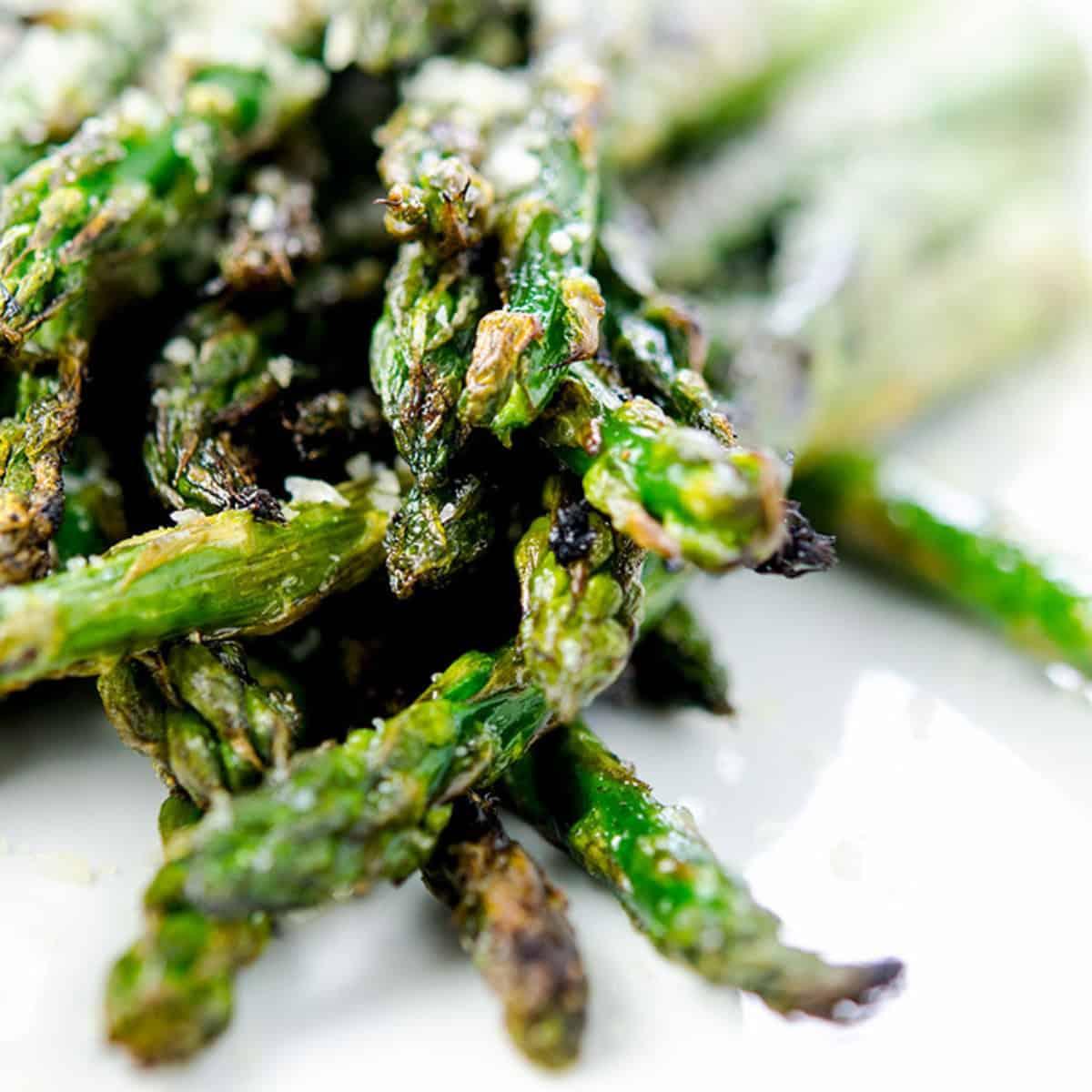 Close-up of grilled asparagus spears with visible char marks and glaze dripping