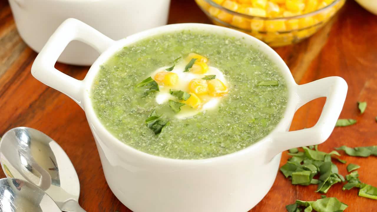 A person enjoying a bowl of creamy kale and spinach soup