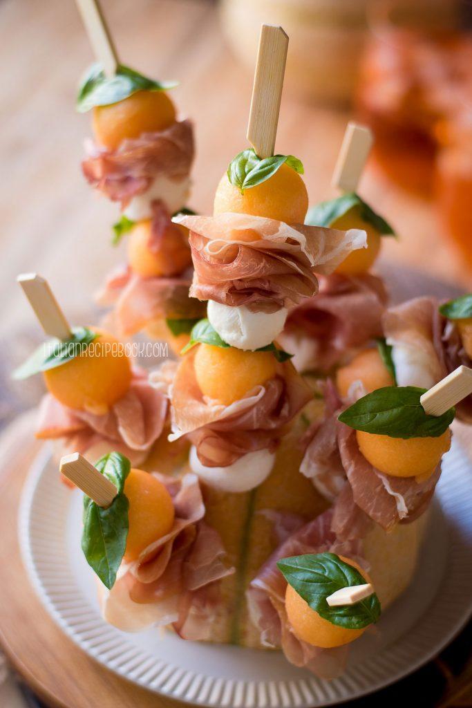 Close-up shot of a prosciutto melon baklava skewer with honey drizzle