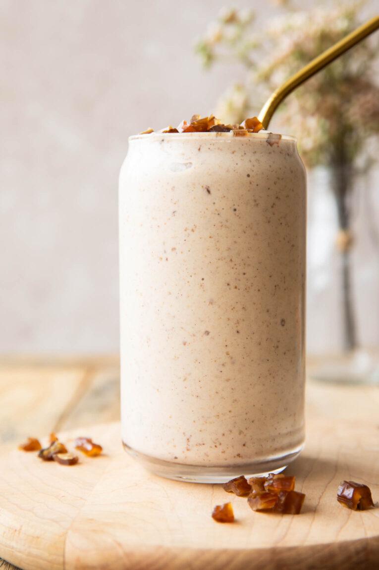 a close-up shot of a date almond smoothie being poured into a glass