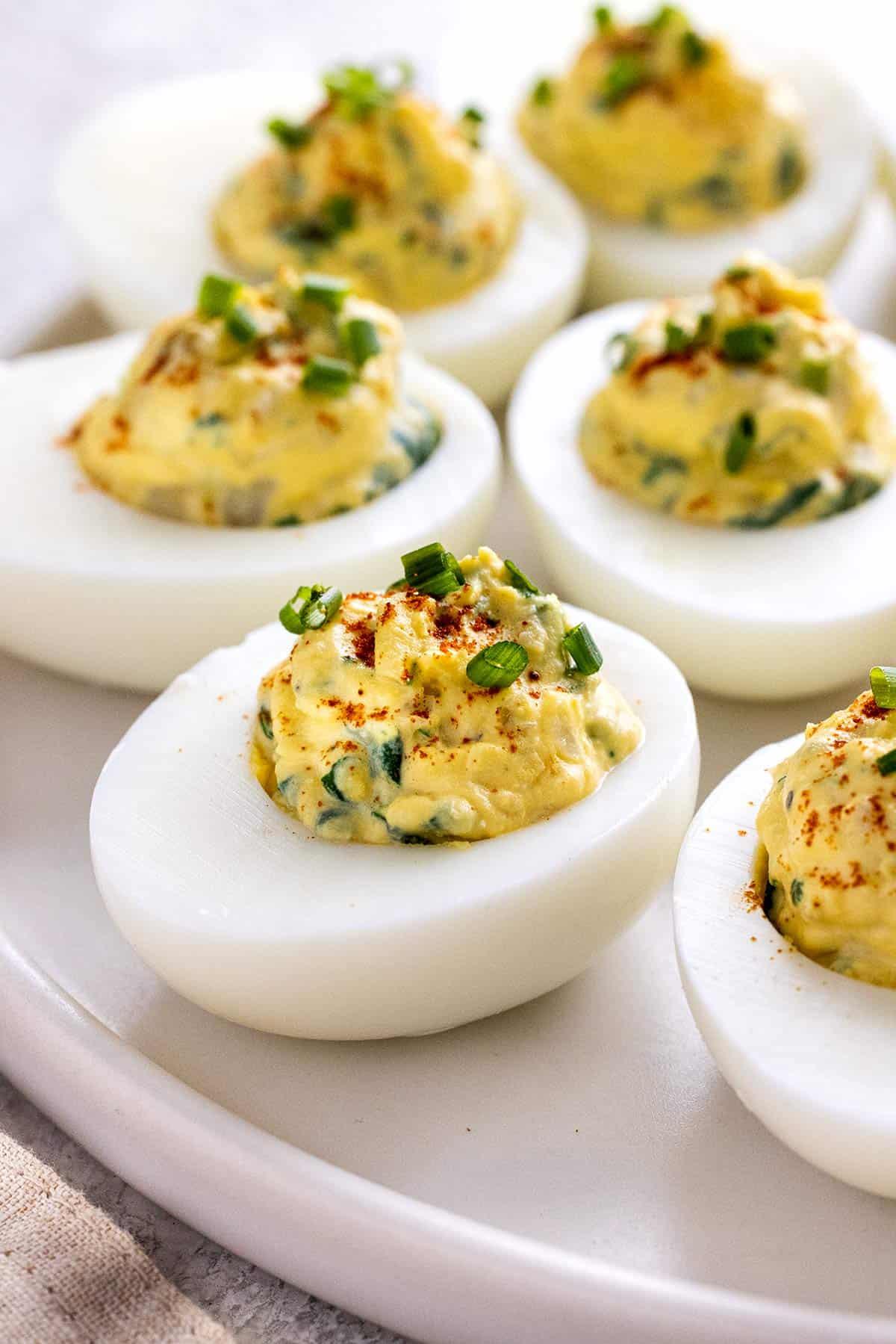 deviled eggs topped with spinach artichoke dip