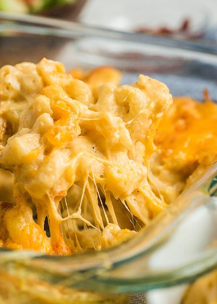 Close-up shot of a creamy mac and cheese dish with toasted walnuts sprinkled on top