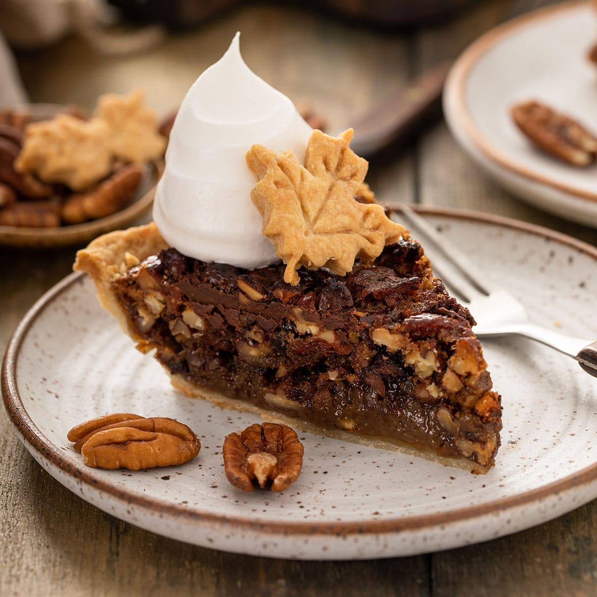 Decadent chocolate pecan pie with a fudgy center, golden crust, sliced with a scoop of vanilla ice cream
